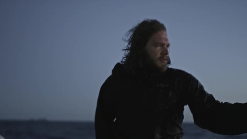 A bearded man riding a boat