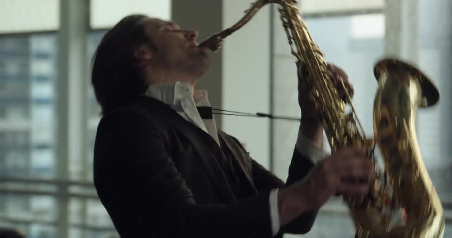 A man in a suit playing a saxophone