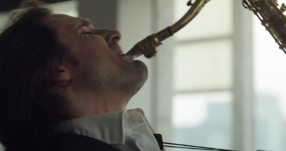 A male musician plays the saxophone