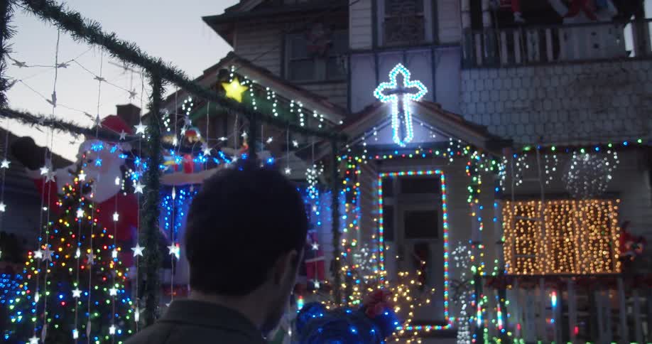 Father and son watching the holidays lights on display at a house