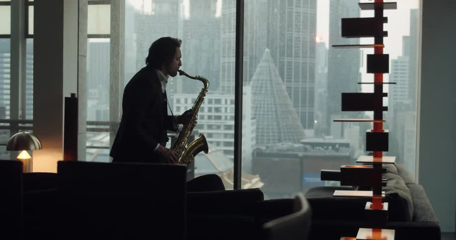 A man is playing a trumpet in a downtown area