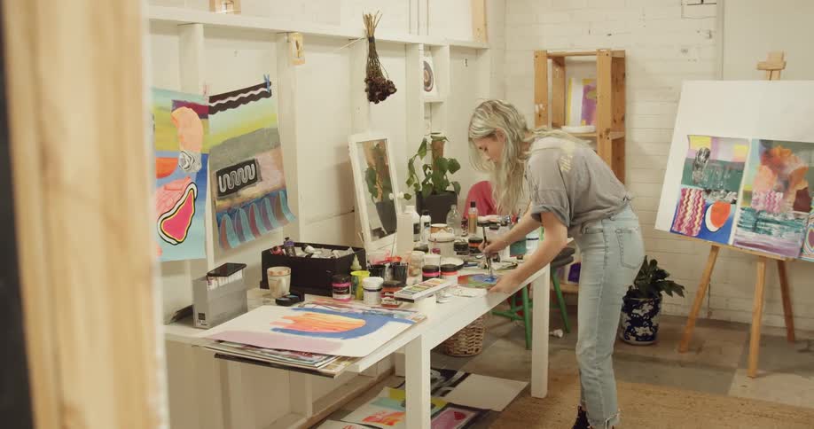 Artist mixes colors then applies paint to canvas