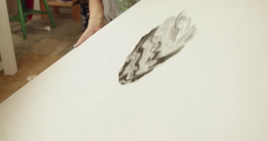 A woman is holding a painting indoors