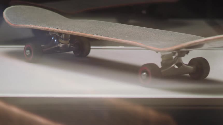 A skateboard sits on a shelf with a mirror back