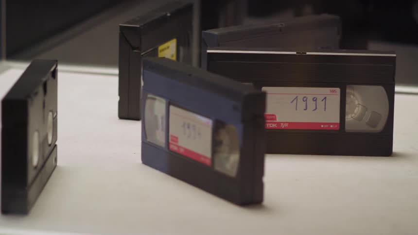Several vhs tapes sit inside of a display case