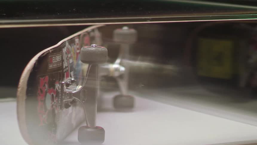 A skateboard sits in a display case in a building