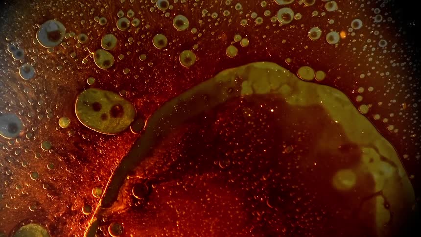 A variety of colors of liquid and oil form together in a large blob