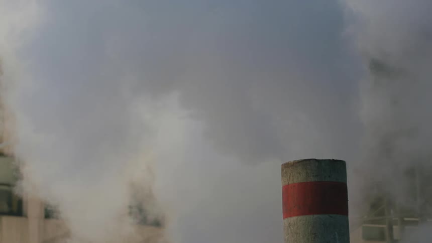 Smoke billows out of a factory chimney