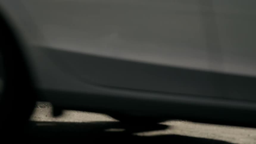 Steam rises from a manhole cover as a car drives past