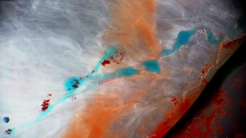 Bands and swirls of colors flow through white translucent fluid