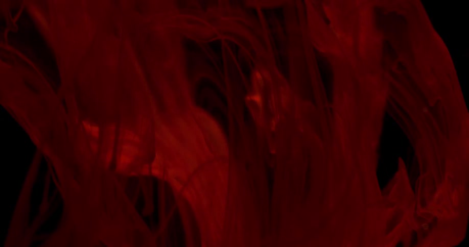 A reddish cloud floating and falling in a sea of black