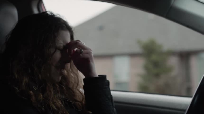 Woman gets in car angrily and hits steering wheel