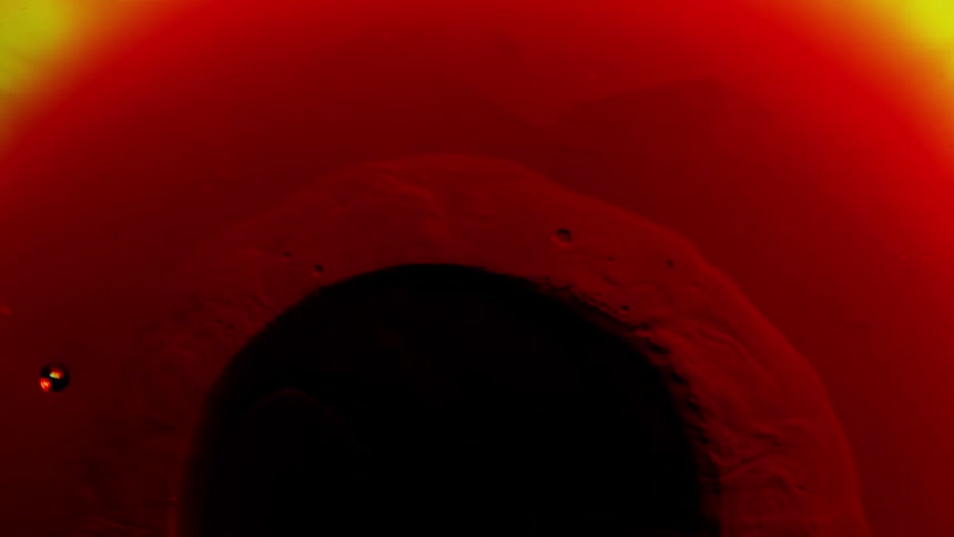 A dark spot sits within a red and orange fluid that is moving and mixing