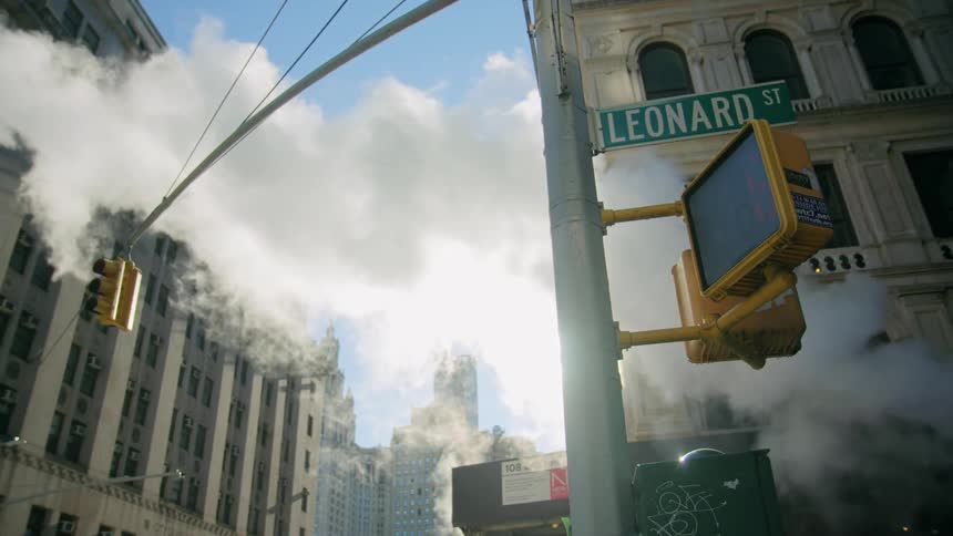 Steam from street man hole rises up in the streets of city