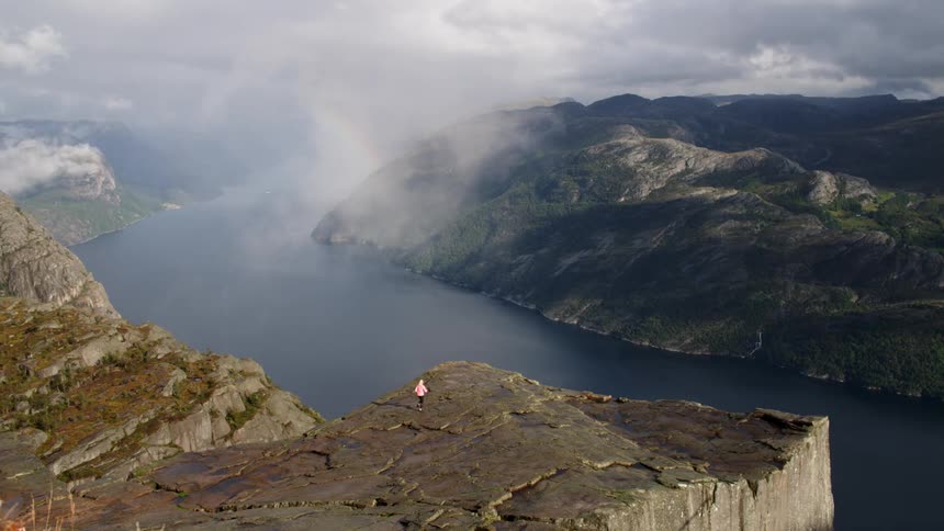 A woman is jogging on a cliff