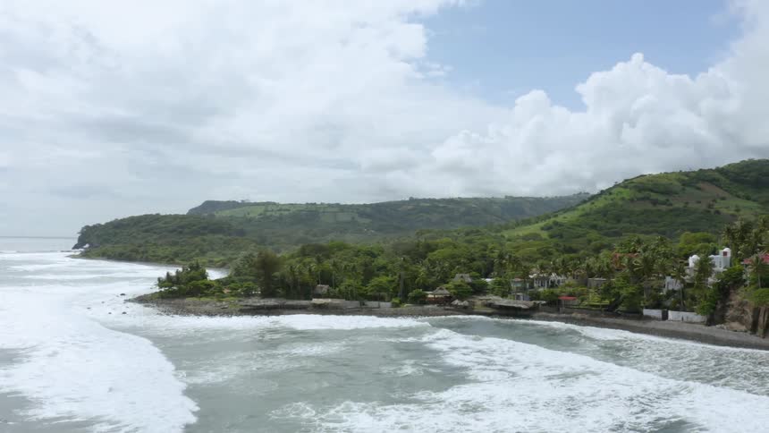 An aerial view of waves moving towards the beach is displayed