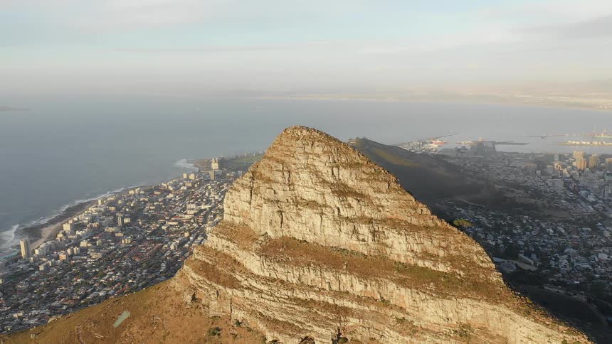 The tall mountain is in the middle of the coastal city