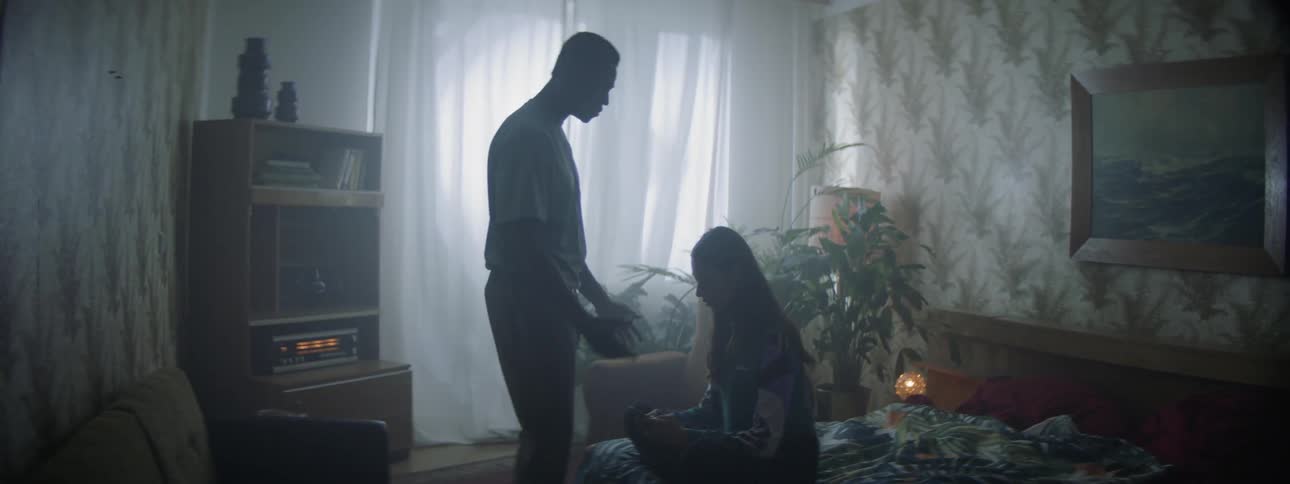 Man enters bedroom to yell at woman sitting on bed