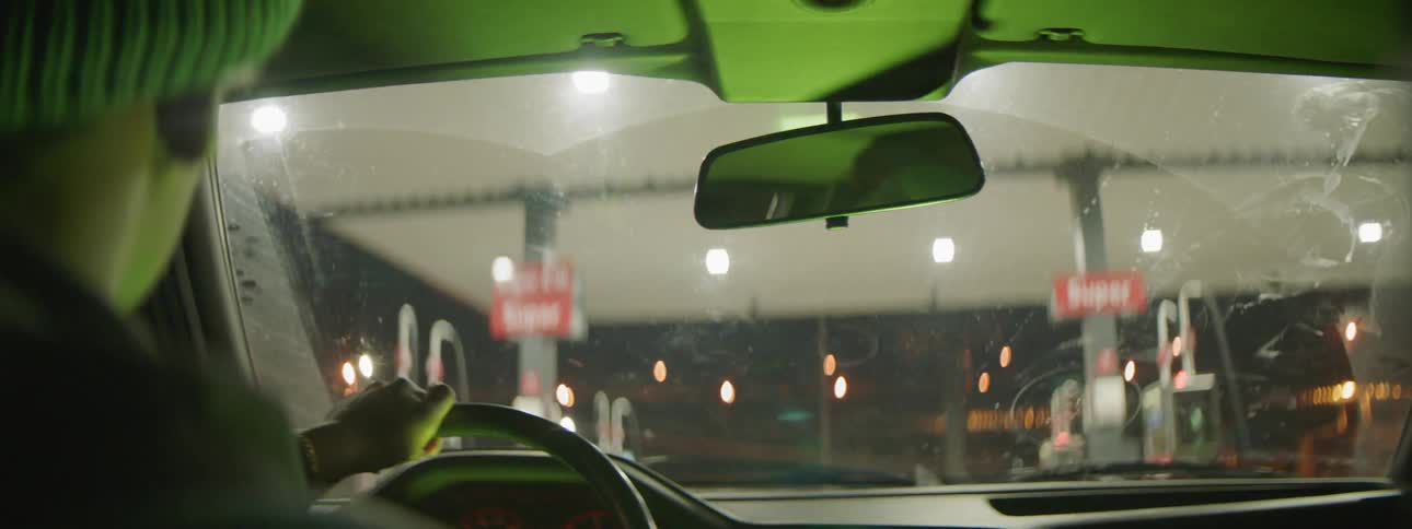 A man drives his car up to a gas station