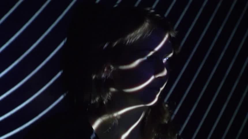 A woman stands in flashing lights