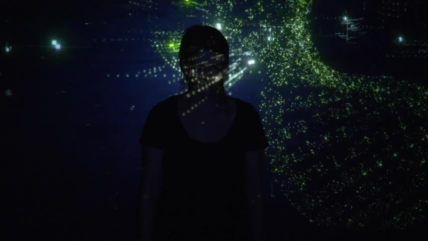 A person stands with lights flashing all over them