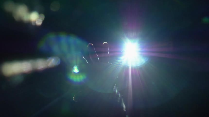 A hand raised high in a dark room with strobe lights