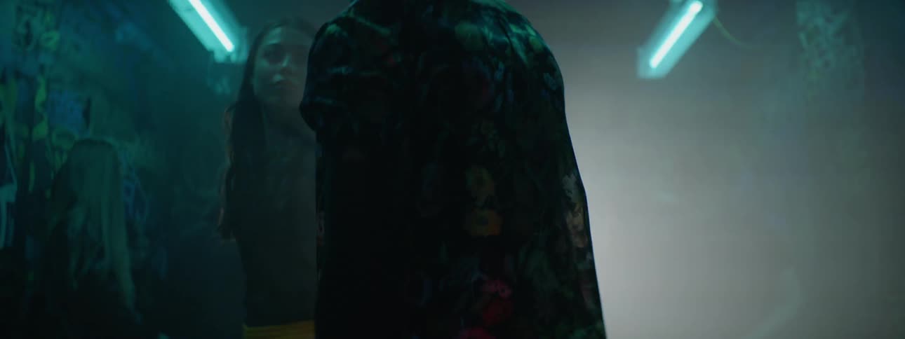 A man and a woman walk out onto a dance floor at a nightclub