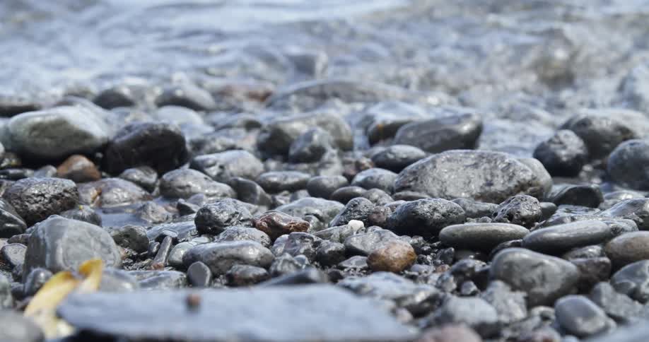 The tide gently rolls over water worn rocks