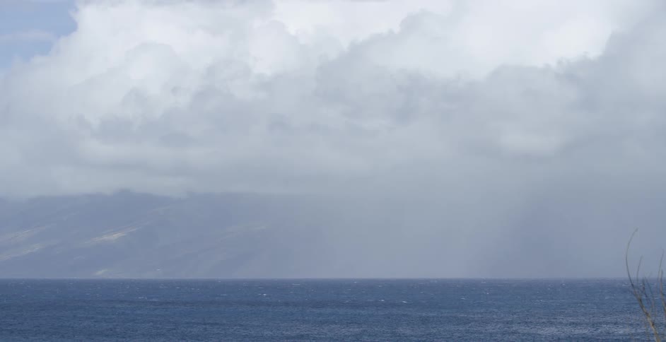 The huge clouds cover the mountains past the water