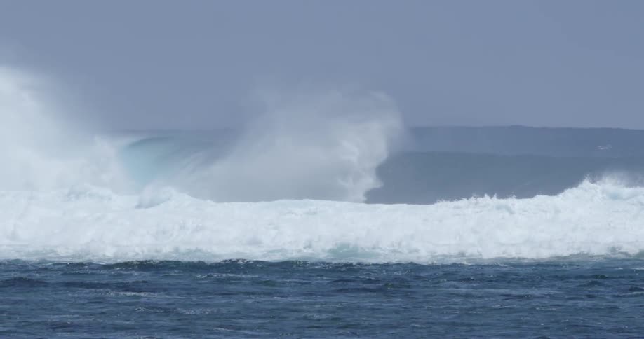 Large waves are forming and crashing toward a coast