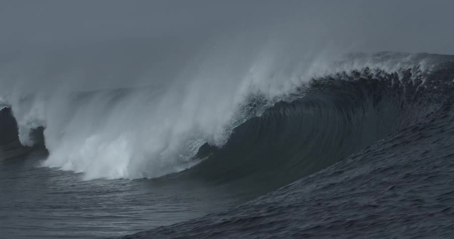 The view of large wave breaking and lots of foam on a cloudy day