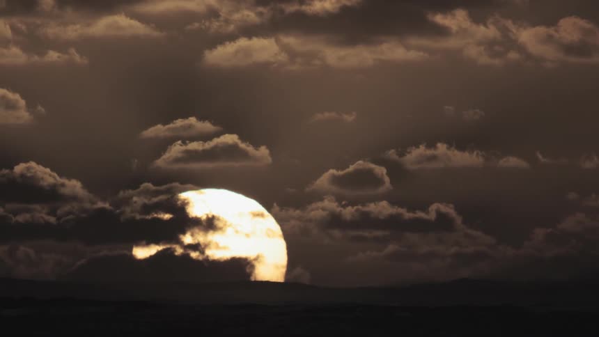 The sun sets across the ocean
