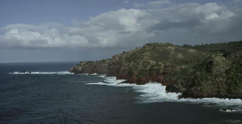 Aerial view of ocean waves crashing into coastal cliff