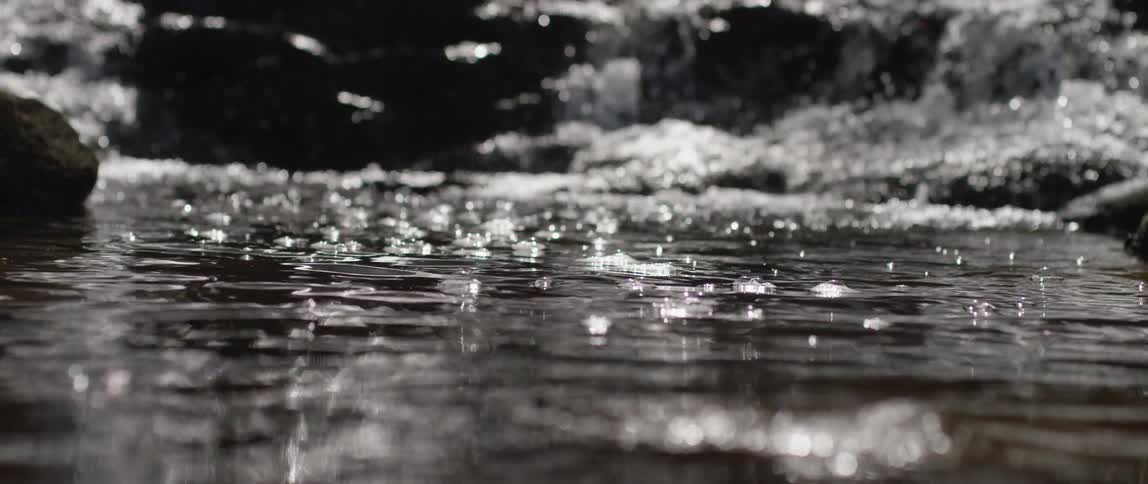 The water in the stream rushes over the rocks
