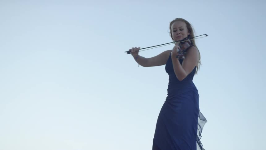 A woman is playing the violin on a sunny day