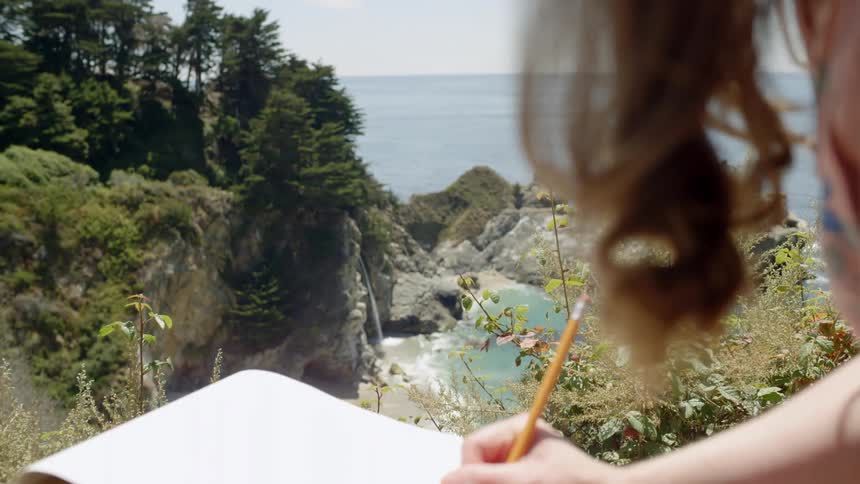 A woman draws near the water