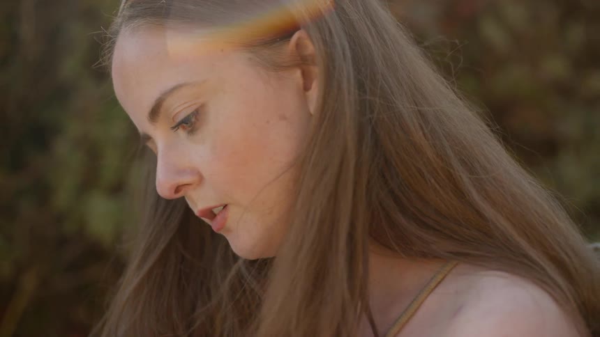 A brunette white woman outdoors looking around