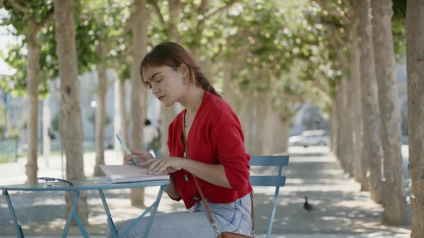 A woman removes her glasses from her bag and opens her book