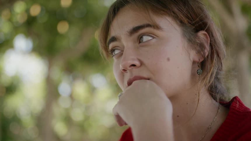 A woman is outdoors and thinking