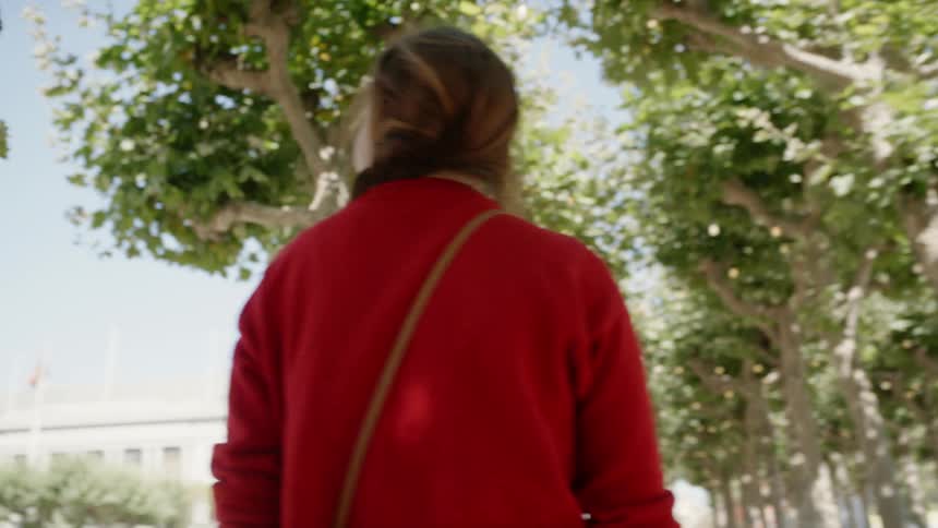 A woman walks along a sidewalk