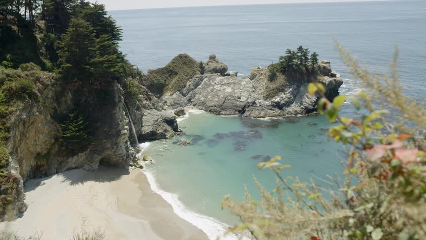 A small waterfall pours into the ocean