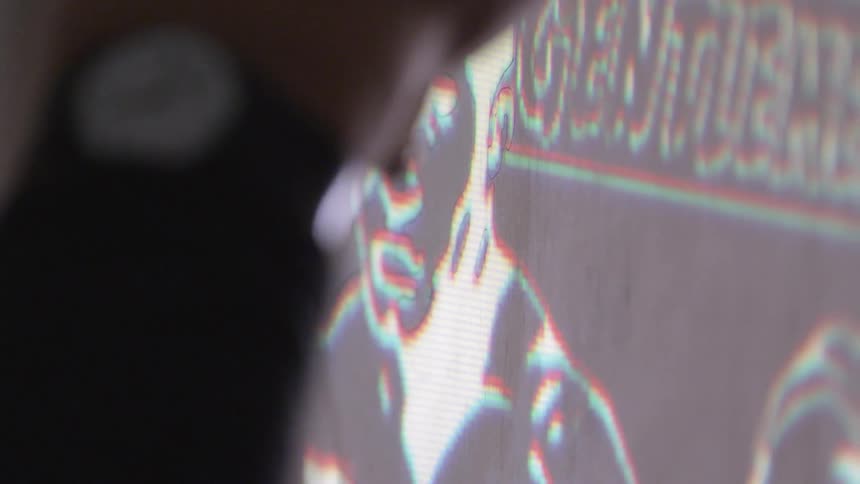 A person is tracing a drawing projected on the wall