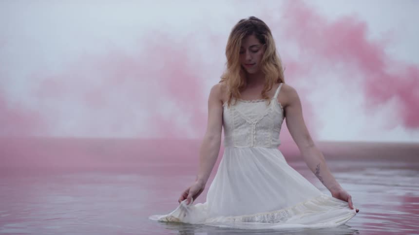 A woman is waving her dress around in the water