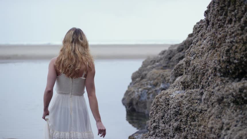 A woman walks to the water