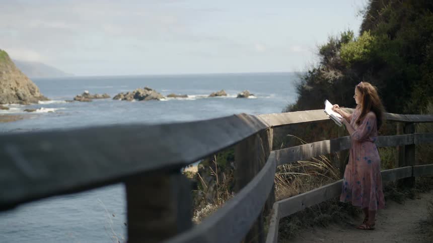 A woman draws near the water