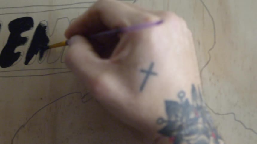 Person painting letters with black paint
