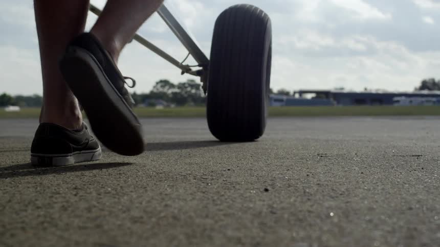 A man pushes a plane into place on a runway