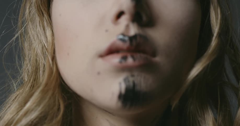 A woman has black paint on her face