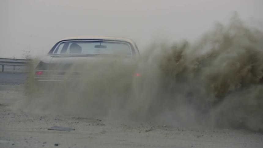 A car spins and the tires kick up dirt