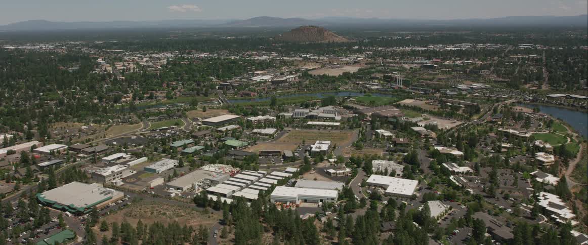 An aerial view of buildings near a river in a town